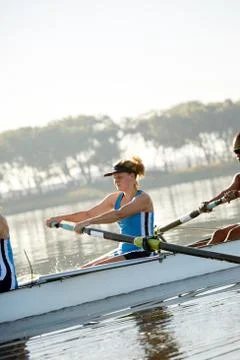 Determined female rower rowing scull on lake Stock Photos