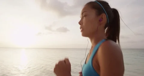 Determined Female Runner Jogging At Beach During Sunset Video stock 73436799