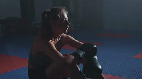 A determined fighter resting in a training facility after an intense boxing Stock Footage 285930051