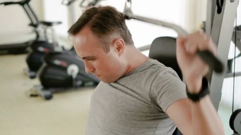 Determined fit athletic young man in grey t-shirt doing exercises on weight Stock Footage 75421837