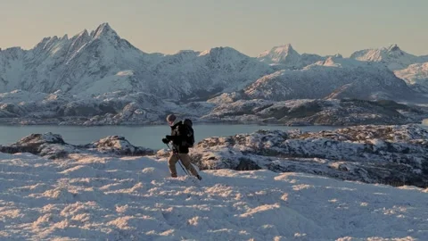 A determined hiker with a backpack ascending to the mountain's summit, embodying Stock Footage 258659225
