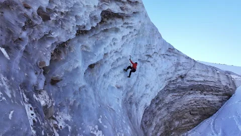 Determined ice climber ascending a sheer glacial wall, Bogdanovich glacier Stock Footage 320519594