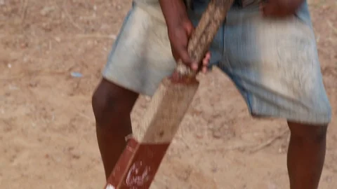 Determined Indian Boy Taps Cricket Bat and Swings Stock Footage 129110035