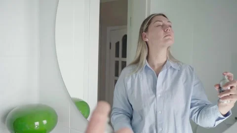 Determined Job Seeker Spraying Face Mist in Front of Mirror Stock Footage 341465941