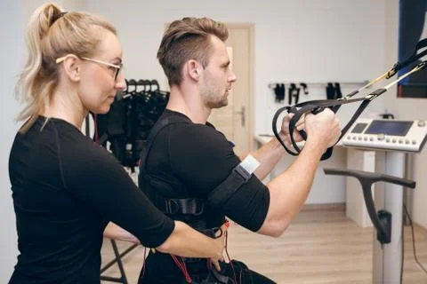 Determined man doing ems training with his coach Foto stock