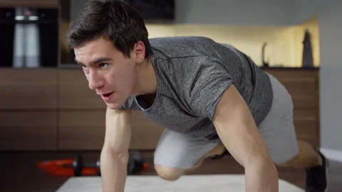 Determined man doing running plank at home Stock Footage 128763595