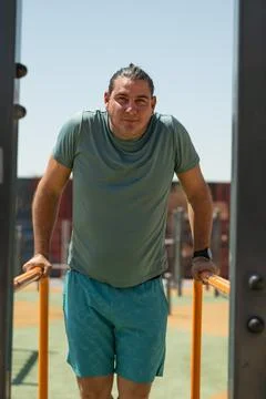 Determined man exercising on parallel bars at outdoor gym 스톡 사진