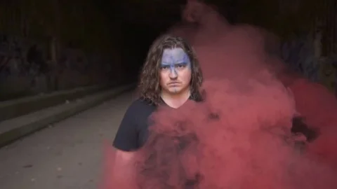 Determined Man Standing in Red Smoke Stock Footage 81494096