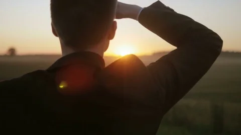 Determined man thinking about the future as he looks at the sun Stock Footage 71928776