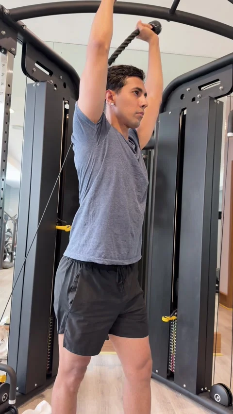 Determined man working out his triceps using cable crossover machine in gym Vídeos de archivo 342351265