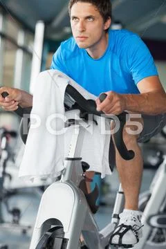 Determined man working out at spinning class Stock Photos