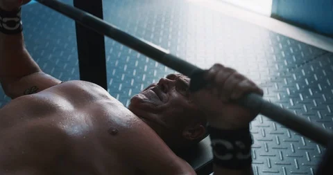 Determined mature man doing bench press exercise for chest Stock Footage 116389955