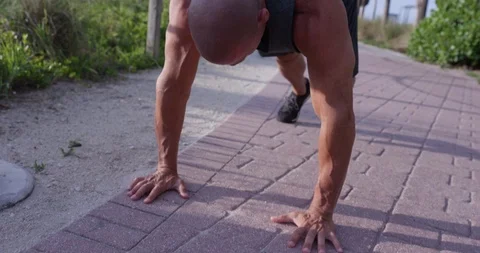 Determined mature man doing push-ups in the park Stock Footage 116375675