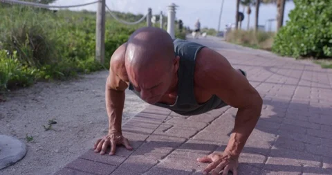 Determined mature man doing push-ups in the park Video stock 116376009