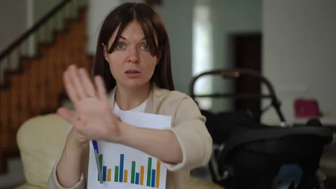 Determined mother presenting a business chart during a video conference call 스톡 동영상 331303754