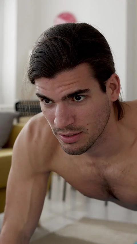 Determined shirtless man doing plank exercise at home Stock Footage 345386627