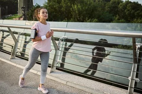 Determined strong athletic middle aged Hispanic woman jogger in sportswear du Stock-Fotos