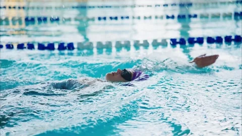 A determined swimmer executing a smooth backstroke in a shimmering pool Stock Footage 317094900