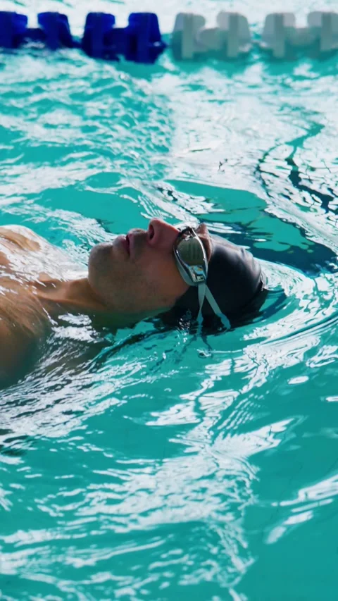 Determined swimmer practices freestyle stroke in calm pool water Stock Footage 346457982