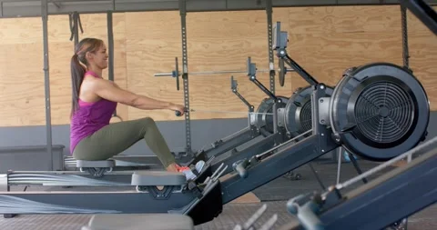 Determined unaltered woman exercising on rowing machine at gym, in slow motion 스톡 동영상 341240025