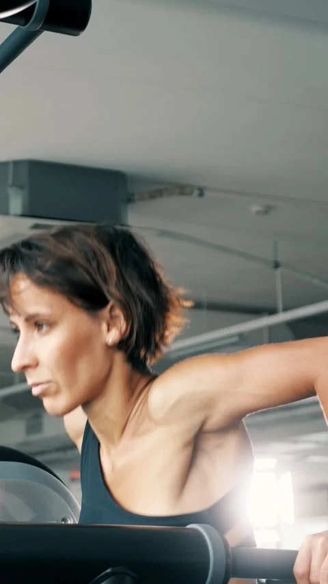 Determined woman performing triceps dips at gym Stock Footage 341447511