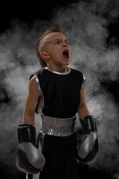 Determined young boy with a punk mohawk haircut wearing black boxer uniform a Stock Photos
