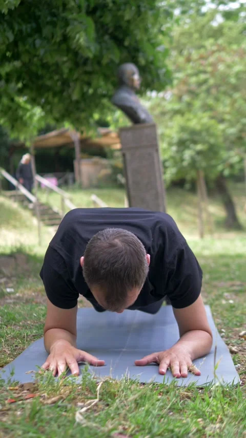 Determined Young Man Holding Plank Position During Outdoor Park Workout Stock Footage 335696644