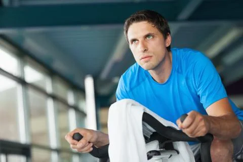 Determined young man working out at spinning class 写真素材