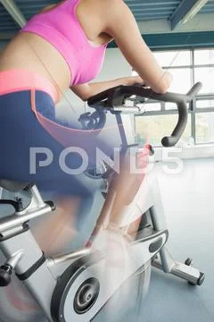 Determined young woman working out at spinning class Stock Photos