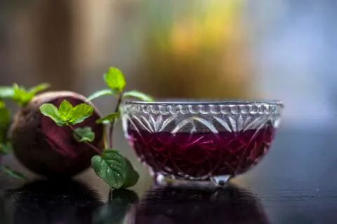 Detoxifying Beetroot extracted tincture in a glass bowl on black glossy surfa Stock Photos
