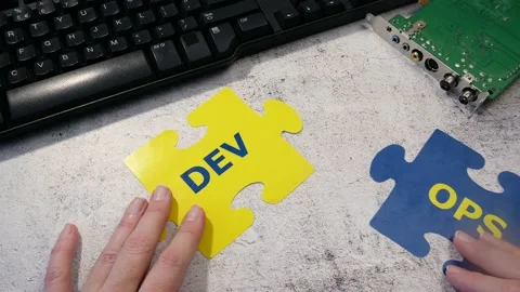 Dev and Ops symbol in hand on motherboard and keyboard background. DevOps Con Stock Footage 211807214