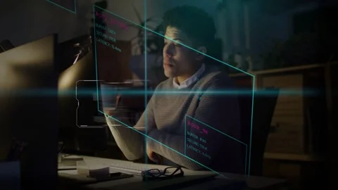 Dev reading monitor code update late, sipping mug to stay focused while holo Stock Footage 333019403