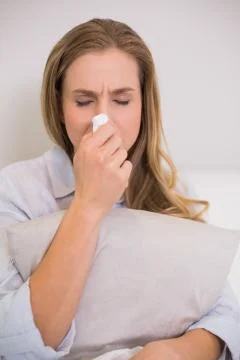 Devastated casual blonde sitting on couch crying Foto stock