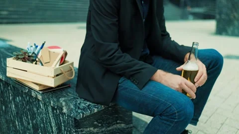 Devastated worker leaning forward on public stairs drinking beer. Substance 库存影片 346998458