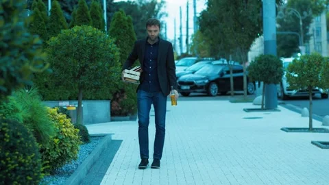 Devastated worker walking down street drinking beer with office box. Financial Vídeos de archivo 346998510