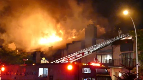Devastating residential building fire at night keeps crews busy Stock Footage 113323531
