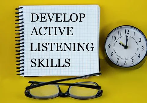 DEVELOP ACTIVE LISTENING SKILLS - words in a white notebook with alarm clock  Stock Photos