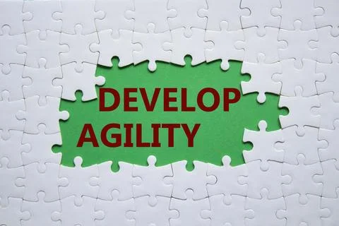 Develop agility symbol. Concept word Develop agility on white puzzle. Beaut.. Stock Photos