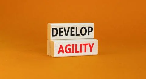Develop agility symbol. Concept words Develop agility on wooden blocks on a b Stock Photos