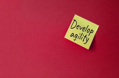 Develop agility symbol. Orange steaky note with concept words Develop Agili.. Stock Photos