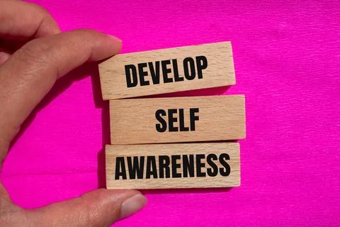 Develop self awareness message written on wooden blocks with pink background. Stock Photos