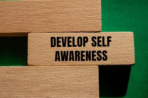 Develop self awareness message written on wooden block with green background. Stock Photos
