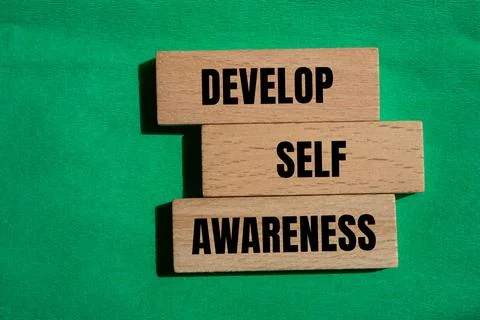 Develop self awareness words written on wooden blocks with green background.  Stock Photos
