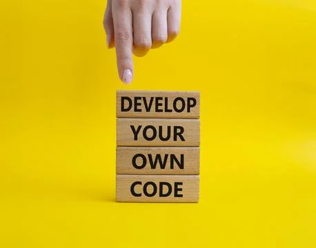 Develop your own code symbol. Concept words Develop your own code on wooden.. Foto stock