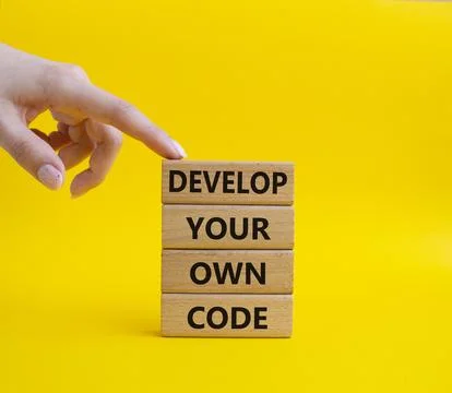 Develop your own code symbol. Concept words Develop your own code on wooden.. Stock Photos