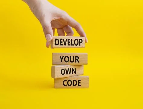 Develop your own code symbol. Concept words Develop your own code on wooden.. Stockfoto's