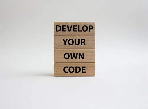 Develop your own code symbol. Concept words Develop your own code on wooden.. Foto stock