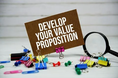 Develop Your Value Proposition text on paper card with magnifying glass and.. Stock Photos
