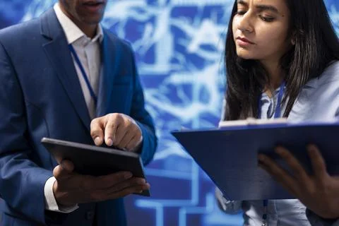 Developer and colleague analyzing complex AI brain models on tablet Stockfoto's