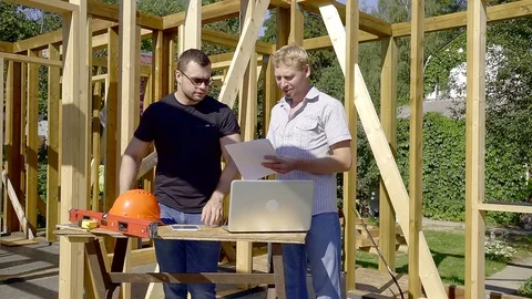 Developer and customer are standing inside building house between wooden beams Stock Footage 93507006